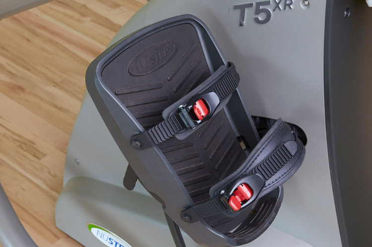 Nustep t5xr recumbent cross trainer with a reclining seat and adjustable handles for safe clinical rehabilitation sessions.